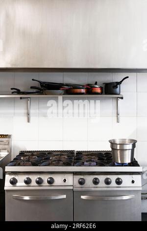 Water boiling on commercial kitchen stove top, enhancing the cooking ambiance. Stock Photo