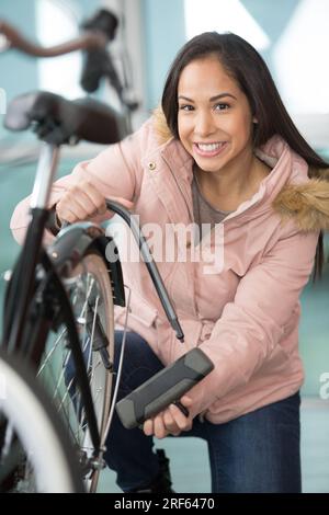 happy woman locking a bike Stock Photo