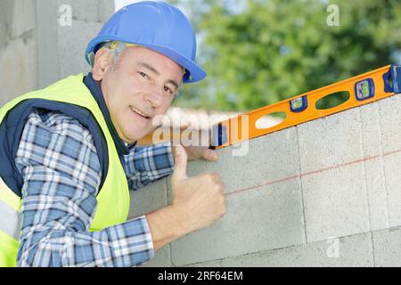 man measuring plane using a spirit level Stock Photo