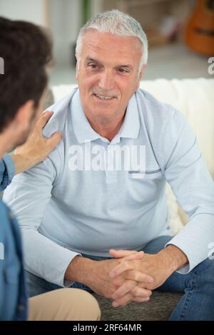 happy old senior dad with young adult grown son Stock Photo