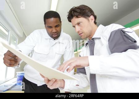 apprentice and painter at work Stock Photo
