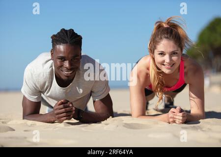 fit couple doing intense workout on beach Stock Photo