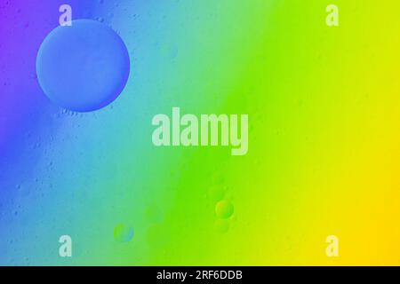 oil on water creating circles on a rainbow background Stock Photo