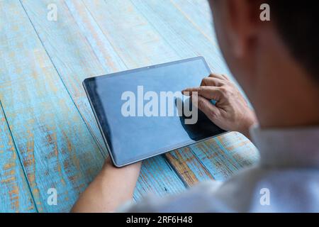 Man using digital tablet by touchscreen. Copy space. Stock Photo