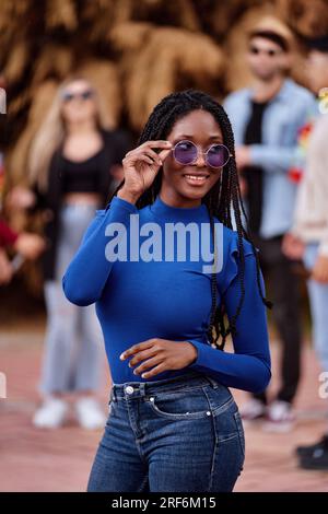 Portrait of beautiful african american woman with dreadlocks and sunglasses looking at camera Stock Photo
