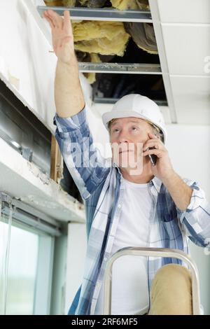 male builder checking state of the ceiling Stock Photo