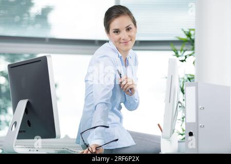 office worker holding eyeglasses looking at the camera Stock Photo