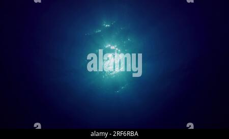 June 24, 2023, Red Sea, Egypt: View of sun light from blue abyss, slow motion. Light filters down through blue water. Underwater sun rays in depth ocean. Underwater light, sun light shine under deep water with ripples on surface (Credit Image: © Andrey Nekrasov/ZUMA Press Wire) EDITORIAL USAGE ONLY! Not for Commercial USAGE! Stock Photo