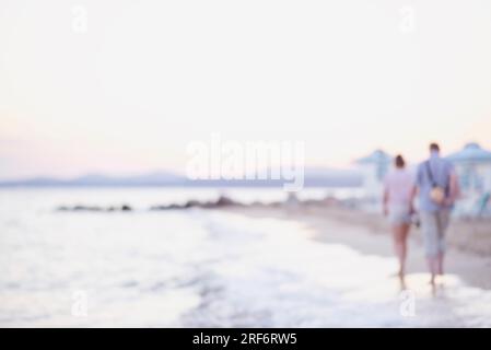 Blur photo of Couple walking in the beach. Romantic Couple Enjoying Beautiful Sunset Walk on the Beach. Stock Photo