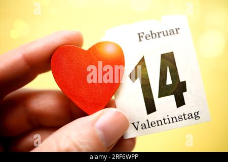 Hand hält rotes Herz und Kalenderblatt vom 14. Februar, Symbolfoto Valentinstag Stock Photo