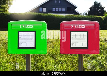 FOTOMONTAGE, Grüner und roter Briefkasten mit Aufschrift 1. Klasse und 2. Klasse, Symbolfoto für eine Zwei-Klassen-Briefzustellung Stock Photo