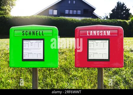 FOTOMONTAGE, Grüner und roter Briefkasten mit Aufschrift schnell und langsam, Symbolfoto für eine Zwei-Klassen-Briefzustellung Stock Photo