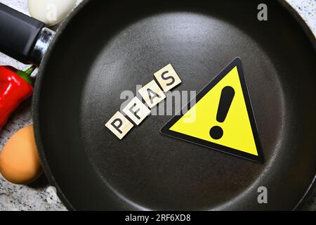 Gefahrenschild mit Ausrufezeichen in Bratpfanne und Schriftzug PFAS Stock Photo