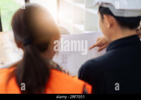 Group of architects and engineers discuss about construction blueprint Stock Photo