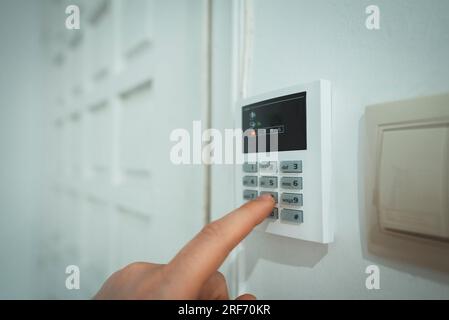 Man putting code in alarm system panel at home. Stock Photo
