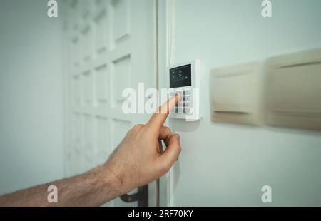 Man putting code in alarm system panel at home. Stock Photo