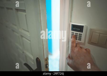 Man putting code in alarm system panel at home. Stock Photo