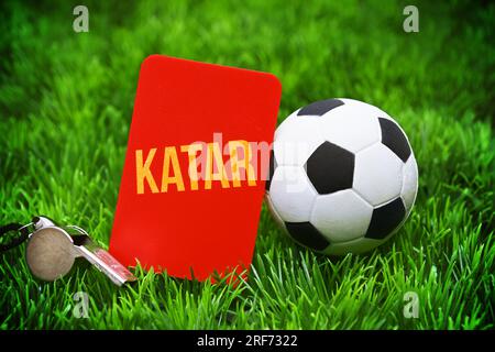 FOTOMONTAGE, Fußball und rote Karte mit Aufschrift Katar auf Fußballrasen, Symbolfoto Boykott der Fußball-Weltmeisterschaft Stock Photo