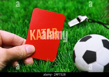 FOTOMONTAGE, Fußball und rote Karte mit Aufschrift Katar auf Fußballrasen, Symbolfoto Boykott der Fußball-Weltmeisterschaft Stock Photo