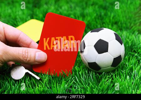 FOTOMONTAGE, Fußball und rote Karte mit Aufschrift Katar auf Fußballrasen, Symbolfoto Boykott der Fußball-Weltmeisterschaft Stock Photo