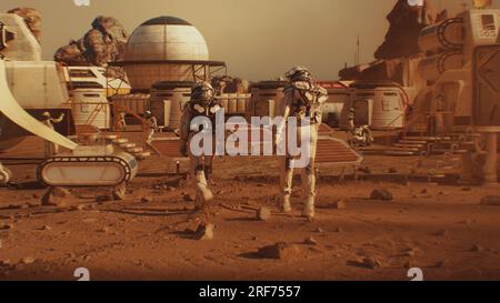 Two astronauts in spacesuits walk toward research station, colony or scientific base on Mars. Solar cell and panels. Space mission on red planet. Futuristic colonization and space exploration concept. Stock Photo
