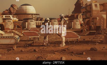 Two astronauts in spacesuits walk toward research station, colony or scientific base on Mars. Solar cell and panels. Space mission on red planet. Futuristic colonization and space exploration concept. Stock Photo