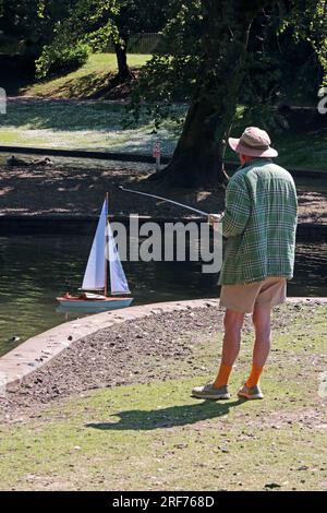 Mature man with remote control yacht on pond in Pavilion Gardens, Buxton Stock Photo