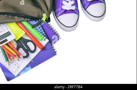 School supplies and a student backpack isolated, white background, top view. Stock Photo