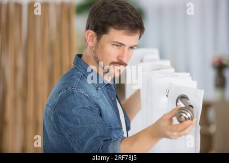 man installing new window blinds in the residential apartment Stock Photo
