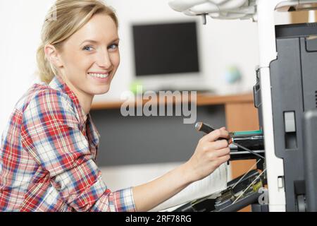 woman fixing printer machine at office Stock Photo