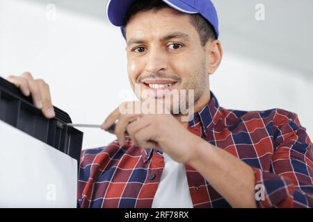 young repairman contractor repairing heating panel Stock Photo