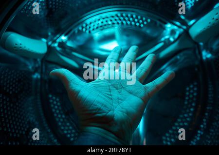 A Hand inside washer in a blue light, future, sci-fi, concept Stock Photo