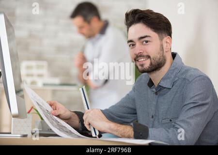 portrait of engineer studying layout plan on the office Stock Photo