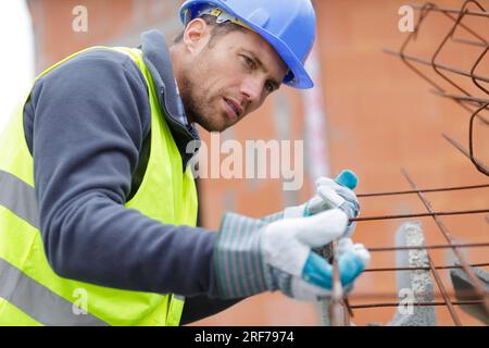 a male builder is working outdoors Stock Photo