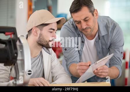 carpenter with apprentice in training period Stock Photo