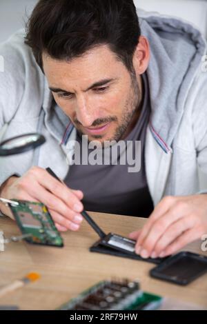 man is repairing broken pc with a screw driver Stock Photo
