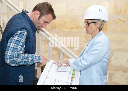 female architect talking to male builder Stock Photo