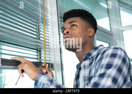 young man measuring a window for blind installation Stock Photo