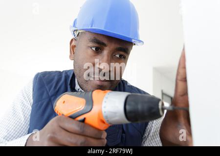 male builder is using a drill Stock Photo