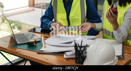 Two engineer working in office with blueprints, inspection in workplace for architectural plan, construction project ,Business construction Stock Photo