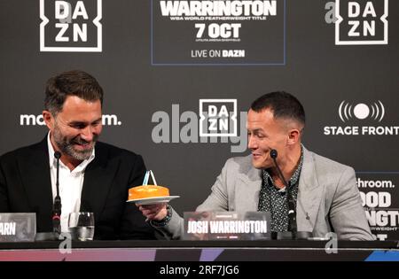 Josh Warrington presents Leigh Wood (not pictured) with a cake on his birthday as promoter Eddie Hearn looks on during a press conference at The Banking Hall, Leeds. Leigh Wood and Josh Warrington will clash in an all-British world featherweight title fight at Sheffield's Utilita Arena on October 7. Picture date: Tuesday August 1, 2023. See PA story BOXING Warrington. Photo credit should read: Danny Lawson/PA Wire. RESTRICTIONS: Use subject to restrictions. Editorial use only, no commercial use without prior consent from rights holder. Stock Photo