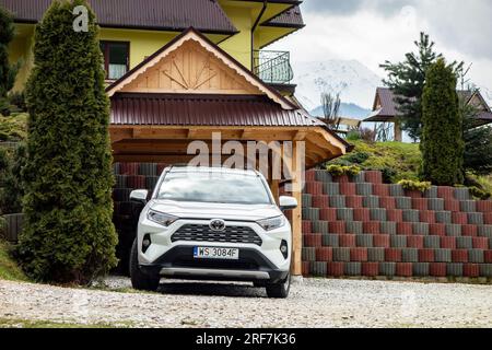 MALE CICHE, POLAND - APRIL 29, 2023: Toyota RAV4 Hybrid SUV car in front of vacation rental house in High Tatras, Poland Stock Photo