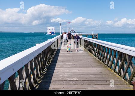 People walking along the pier as the ferry departs at Yarmouth, Isle of Wight, England,UK Stock Photo