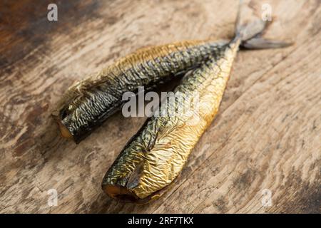 Two hot smoked mackerel, Scomber scombrus on a wooden chopping board that will be used to make a homemade mackerel pate. England UK GB Stock Photo