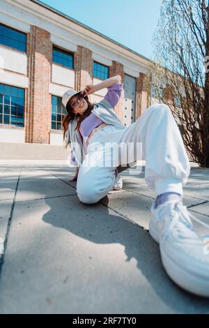 Vertical view of girl performing hip hop dance style having fun freestyle dancer in urban city Stock Photo