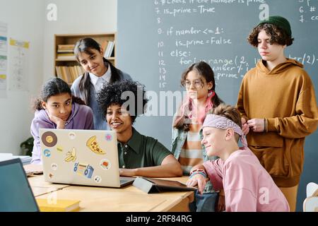 African American teacher using laptop to teach students information technology in the classroom Stock Photo