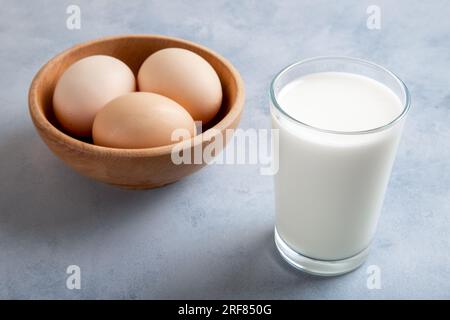A glass of milk on a blue background and eggs in a bowl,top view Stock Photo