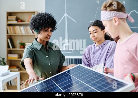 Teacher showing solar panel to students during lesson in classroom Stock Photo