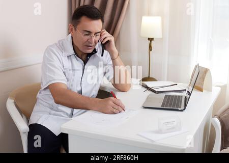 male doctor in white medical uniform using computer laptop Stock Photo