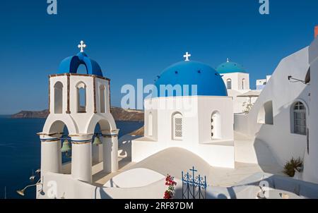 White churches with blue dome - Agios Spiridonas (St Spyridon) and Church of Anastasis (Resurrection), Ia (Oia), Santorini, Greece Stock Photo